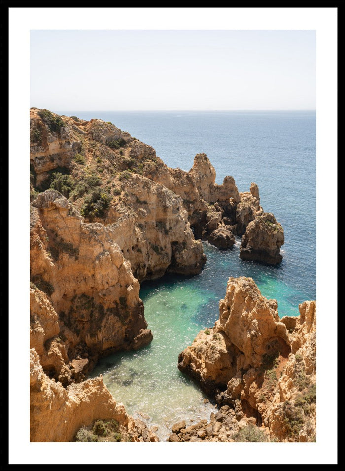 Rocky coastline with clear blue water. Golden Cliffs Azure Ocean by Henrike Schenk is a coastal photography print of rocky sea cliffs overlooking turquoise water and the Mediterranean coastline.