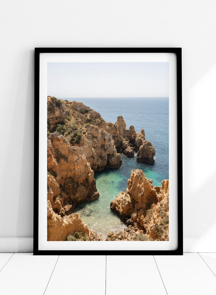 Rocky coastline with clear blue water. Golden Cliffs Azure Ocean by Henrike Schenk is a coastal photography print of rocky sea cliffs overlooking turquoise water and the Mediterranean coastline.