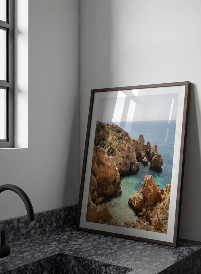 Rocky coastline with clear blue water. Golden Cliffs Azure Ocean by Henrike Schenk is a coastal photography print of rocky sea cliffs overlooking turquoise water and the Mediterranean coastline.