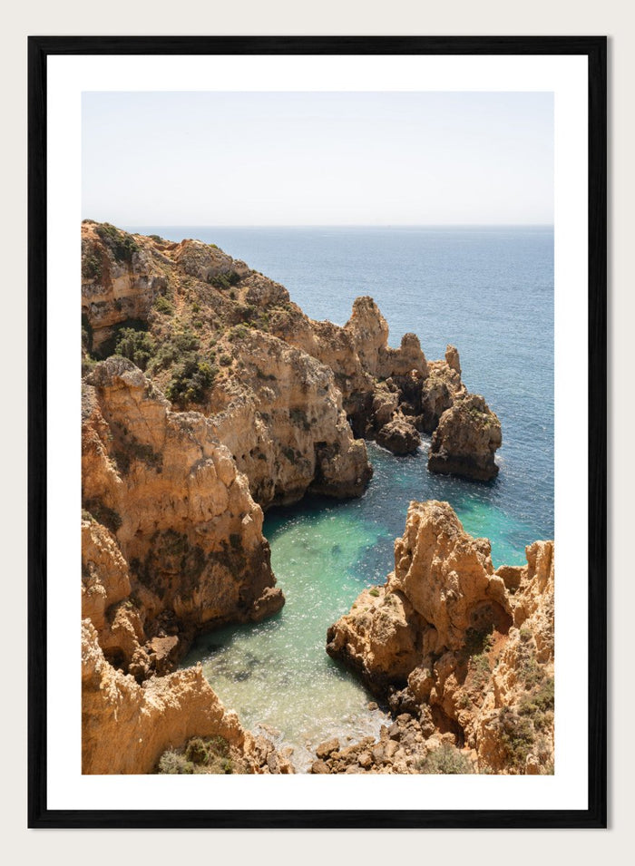 Rocky coastline with clear blue water. Golden Cliffs Azure Ocean by Henrike Schenk is a coastal photography print of rocky sea cliffs overlooking turquoise water and the Mediterranean coastline.