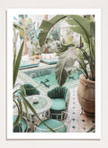 Outdoor patio with pool, green chairs, and potted plants. Green Courtyard Oasis by Henrike Schenk is a Morocco travel photography print showing a lush riad courtyard with green tilework, tropical plants, and poolside interiors.