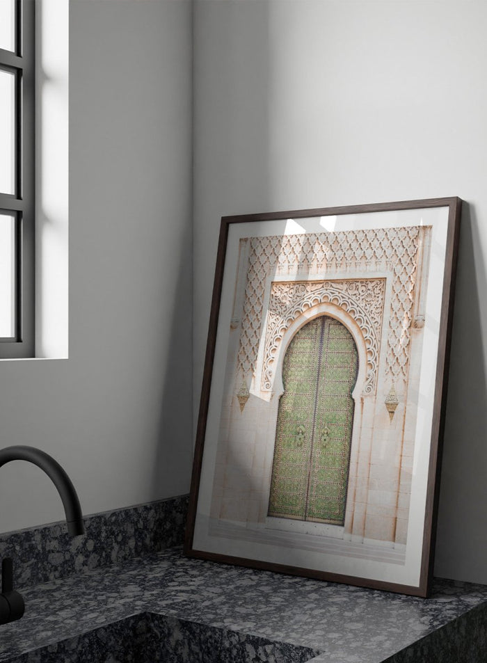 Decorative archway with ornate green door on a light stone wall. Ornate Moroccan Green Door by Henrike Schenk is a Moroccan architecture print featuring an ornate green door, Islamic patterns, and historic stone details.