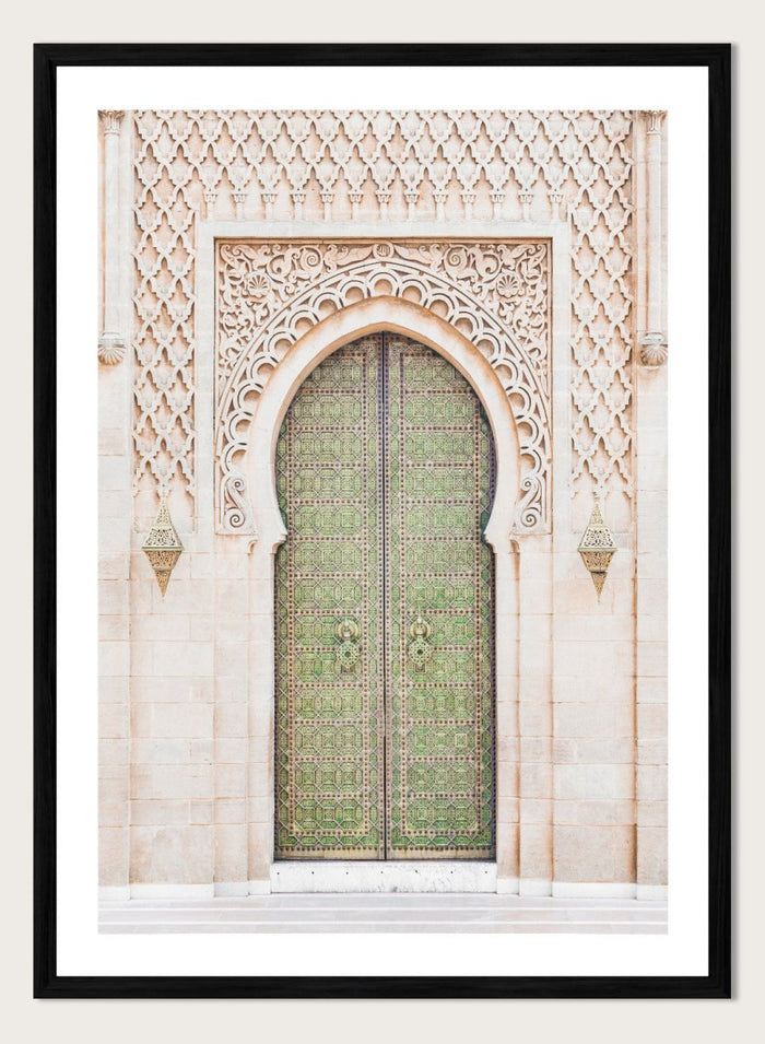 Decorative archway with ornate green door on a light stone wall. Ornate Moroccan Green Door by Henrike Schenk is a Moroccan architecture print featuring an ornate green door, Islamic patterns, and historic stone details.