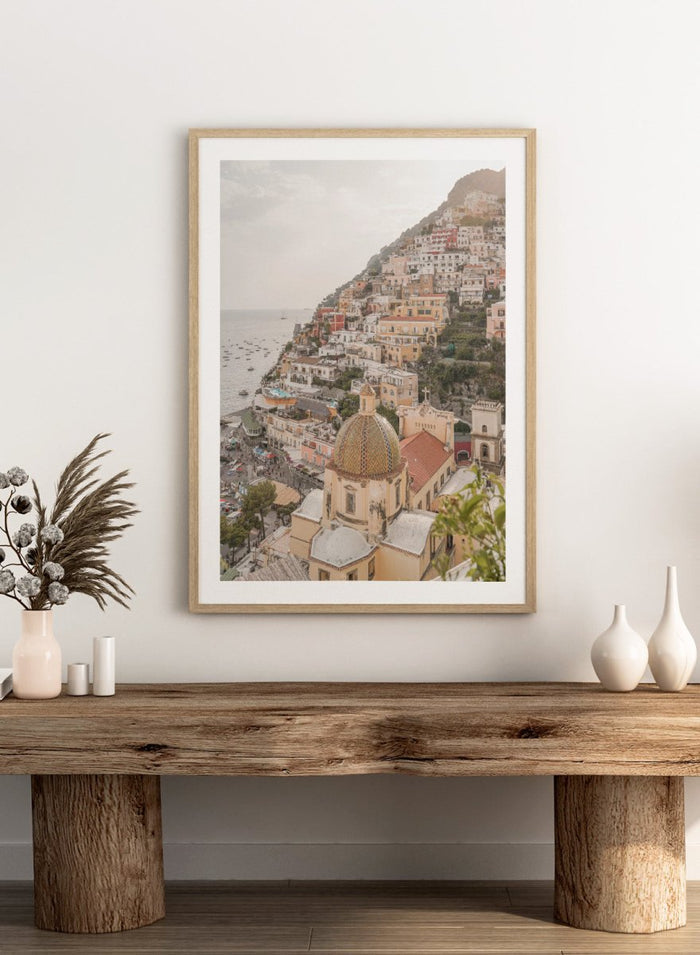 Hilly coastal town with buildings and a church dome. Positano Bliss by Henrike Schenk is a coastal photography print featuring the colorful hillside of Positano, Mediterranean architecture, and the beauty of the Amalfi Coast.