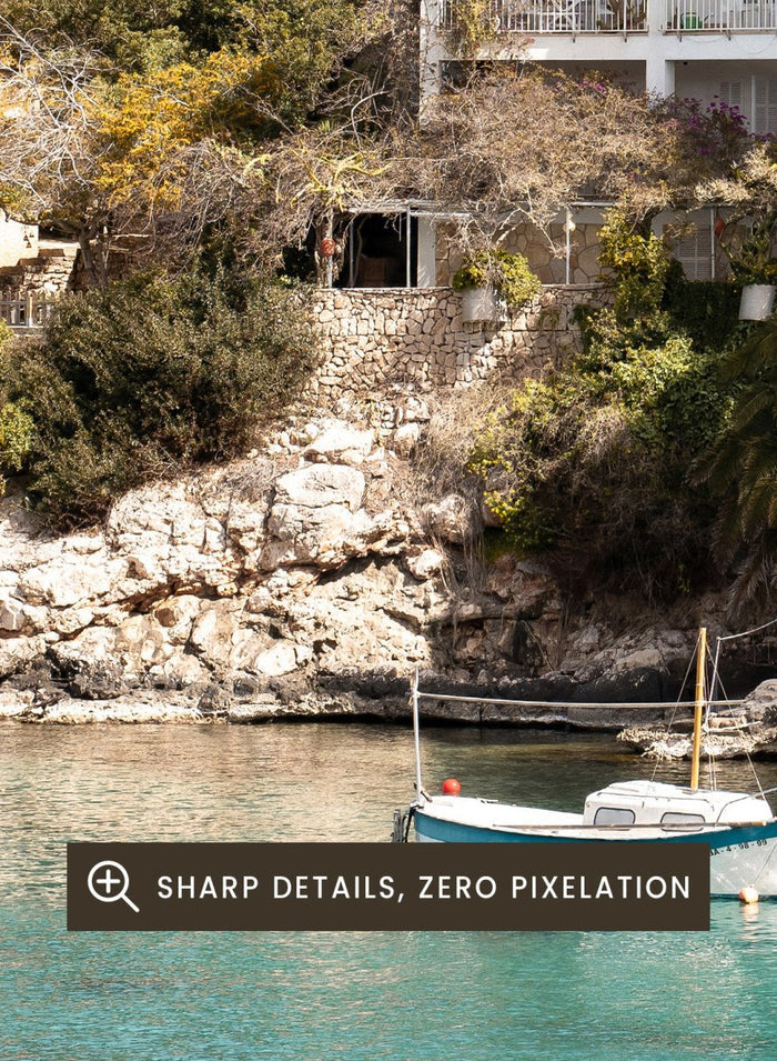 Cottage by a lake with trees and boats in the water. Serene Mediterranean Cove by Henrike Schenk is a coastal photography print featuring turquoise water, a fishing boat, seaside homes, and Mediterranean scenery.