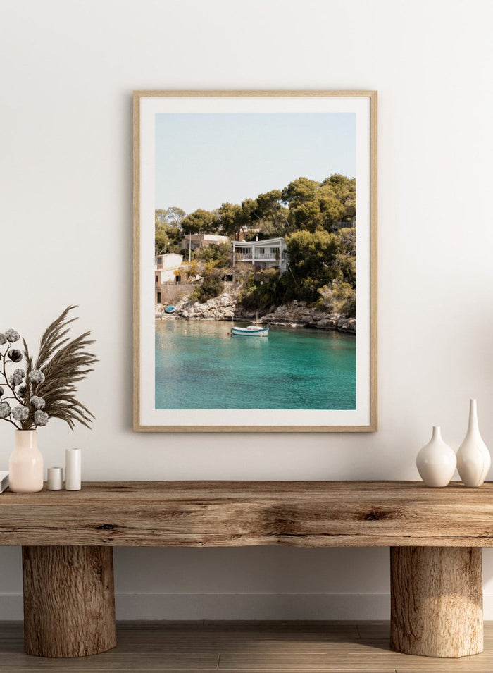 Cottage by a lake with trees and boats in the water. Serene Mediterranean Cove by Henrike Schenk is a coastal photography print featuring turquoise water, a fishing boat, seaside homes, and Mediterranean scenery.