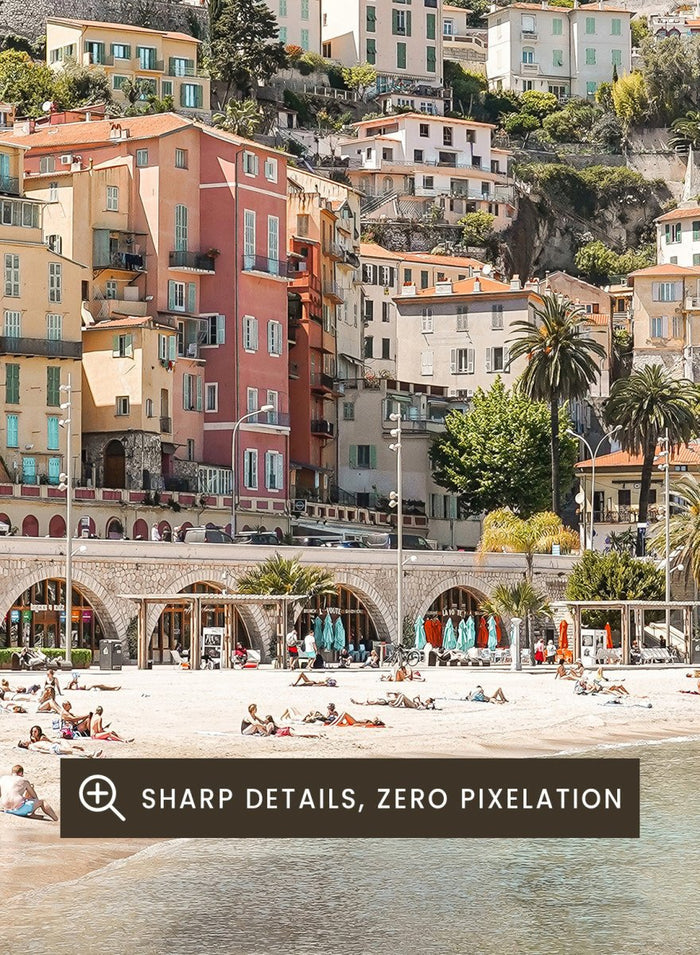 Coastal town with colorful buildings and a beach. Sunny Mediterranean Coast by Henrike Schenk is a coastal photography print featuring turquoise water, pastel buildings, Mediterranean beach scenery, and travel wall art.