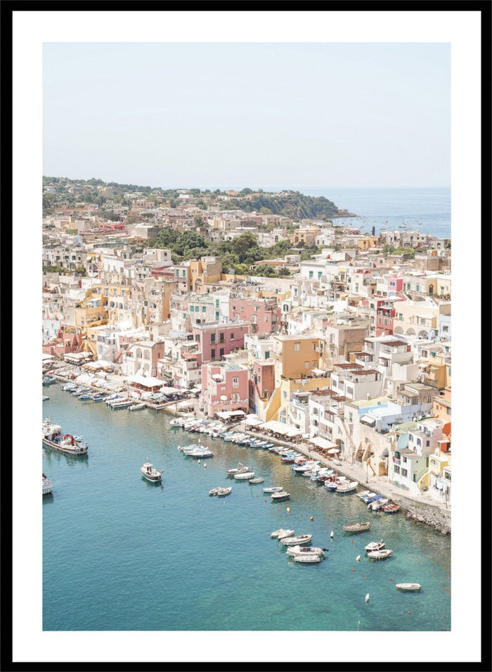 Coastal town with colorful buildings and boats in a harbor. Vibrant Italian Coastal Town by Henrike Schenk is a coastal photography print featuring pastel architecture, turquoise waters, fishing boats, and Mediterranean charm.