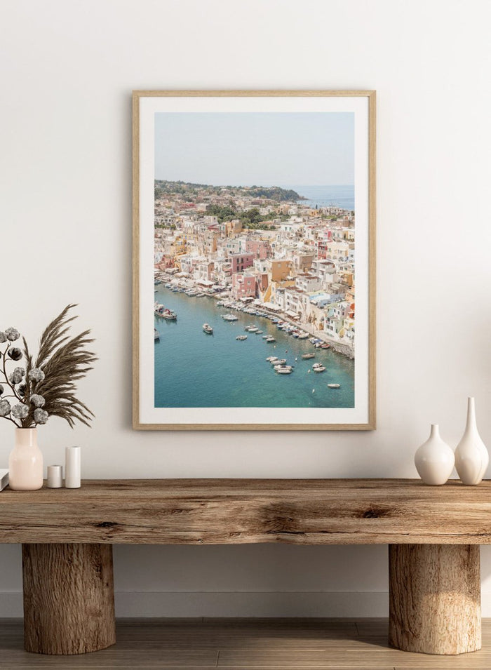 Coastal town with colorful buildings and boats in a harbor. Vibrant Italian Coastal Town by Henrike Schenk is a coastal photography print featuring pastel architecture, turquoise waters, fishing boats, and Mediterranean charm.