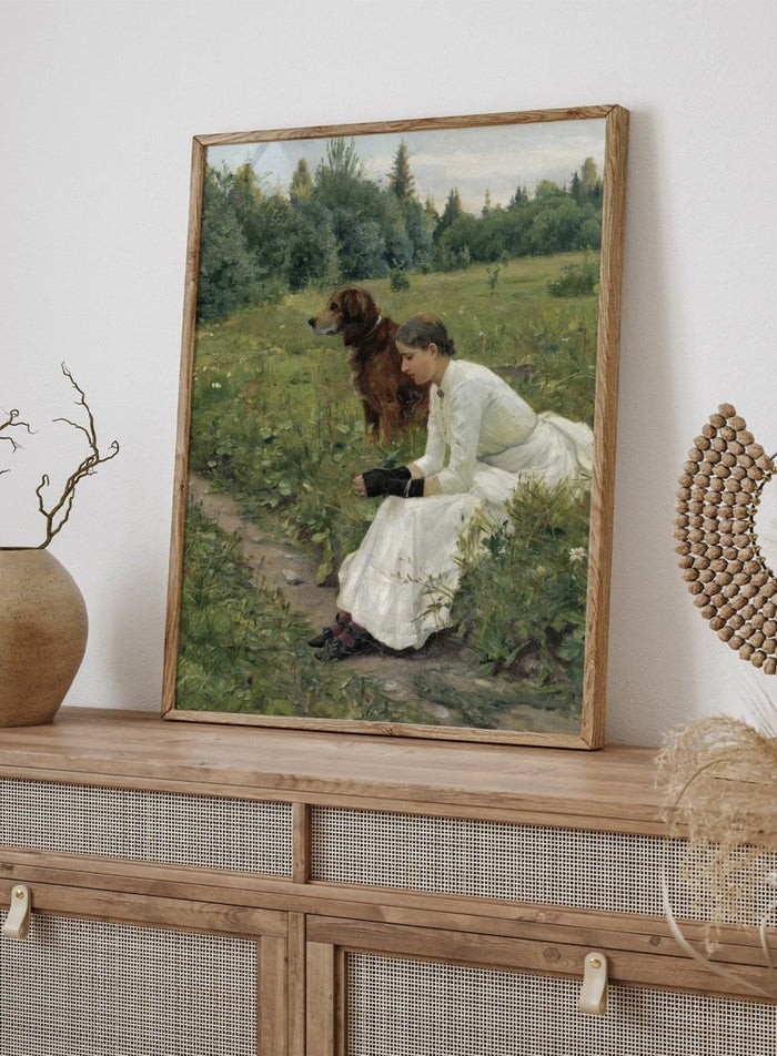 Idyll by Gerhard Munthe is a vintage Norwegian landscape print featuring a woman in a white dress resting with her dog in a green summer meadow.