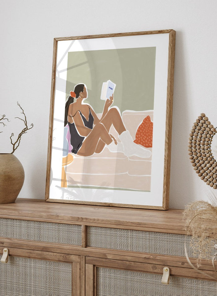 Woman Enjoying a Great Hygge Book by Ivy Green is a cozy modern figure art print celebrating slow living and self-care. Premium fine art print with optional wood framing.
