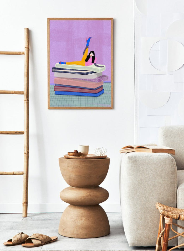Illustration of a person sitting on a stack of books with one arm raised against a purple background. Mattress Ballet by Jota De Jai is a playful modern fine art print of a woman balancing on stacked mattresses. Available unframed or framed in real wood.