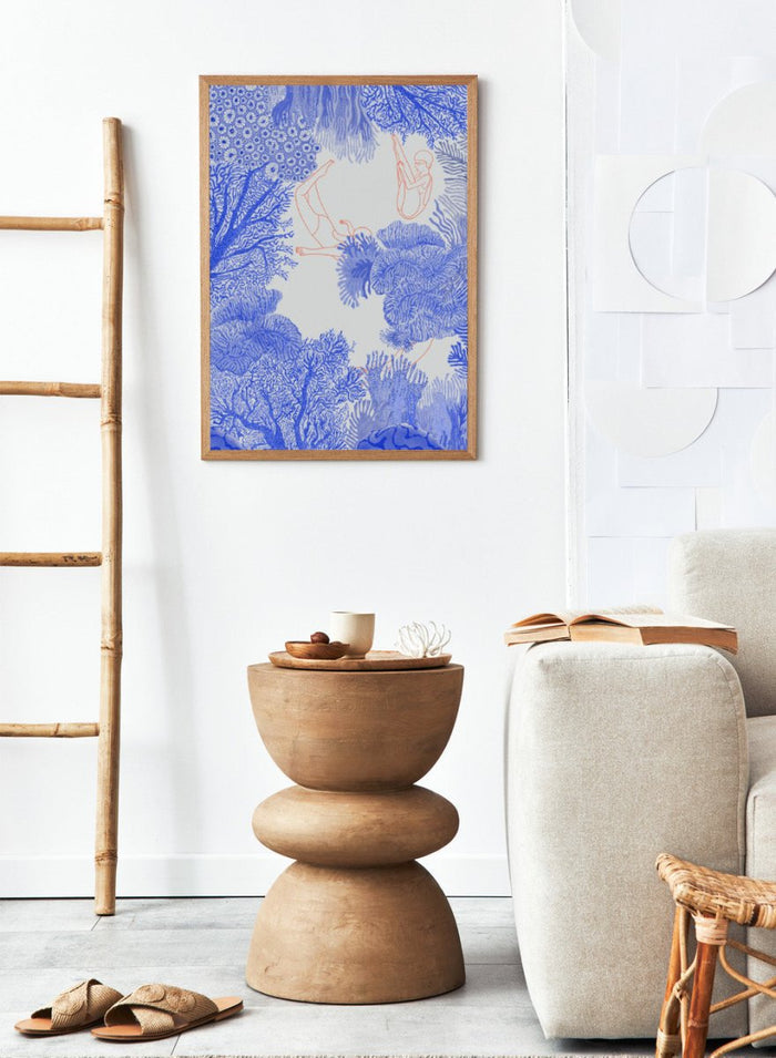 Illustration of people climbing on coral with blue and white patterns. Underwater by Jota de Jai is a modern blue wall art print of swimmers drifting through an ocean coral illustration, available as a premium fine art poster with optional wood framing.