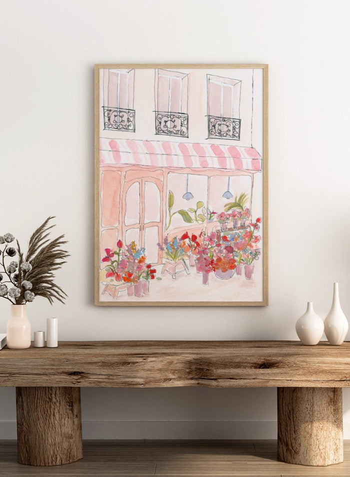 Illustration of a flower shop with a striped awning and flowers in front. Pink Flower Shop by Katharina Puritscher features a Paris-inspired storefront illustration with colorful bouquets, soft watercolor textures, and European street details. Floral art print with optional framing.