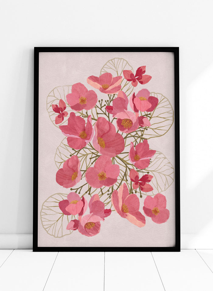 A framed botanical art print featuring pink flowers with yellow centers and delicate gold leaf outlines on a pale pink background. Shop Japanese Quince Floral Art Print by Katie O'Shea, a botanical floral art print featuring pink quince blossoms, soft leaves, and fresh spring color.