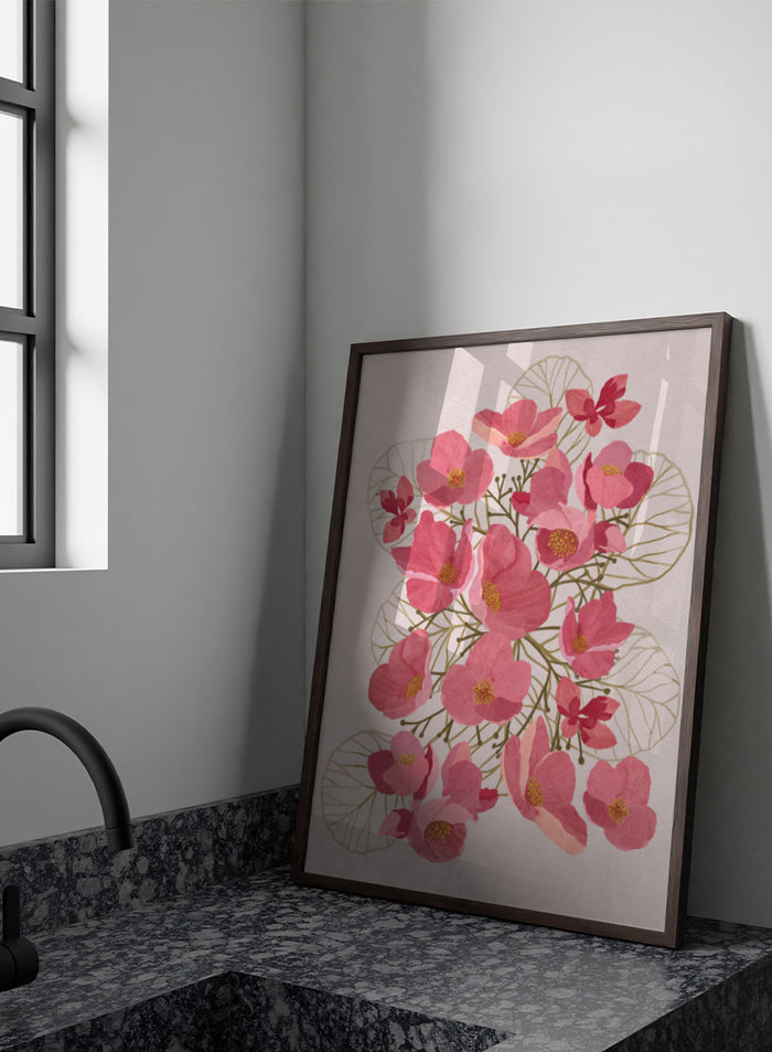 A framed botanical art print featuring pink flowers with yellow centers and delicate gold leaf outlines on a pale pink background. Shop Japanese Quince Floral Art Print by Katie O'Shea, a botanical floral art print featuring pink quince blossoms, soft leaves, and fresh spring color.
