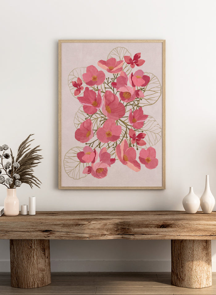 A framed botanical art print featuring pink flowers with yellow centers and delicate gold leaf outlines on a pale pink background. Shop Japanese Quince Floral Art Print by Katie O'Shea, a botanical floral art print featuring pink quince blossoms, soft leaves, and fresh spring color.