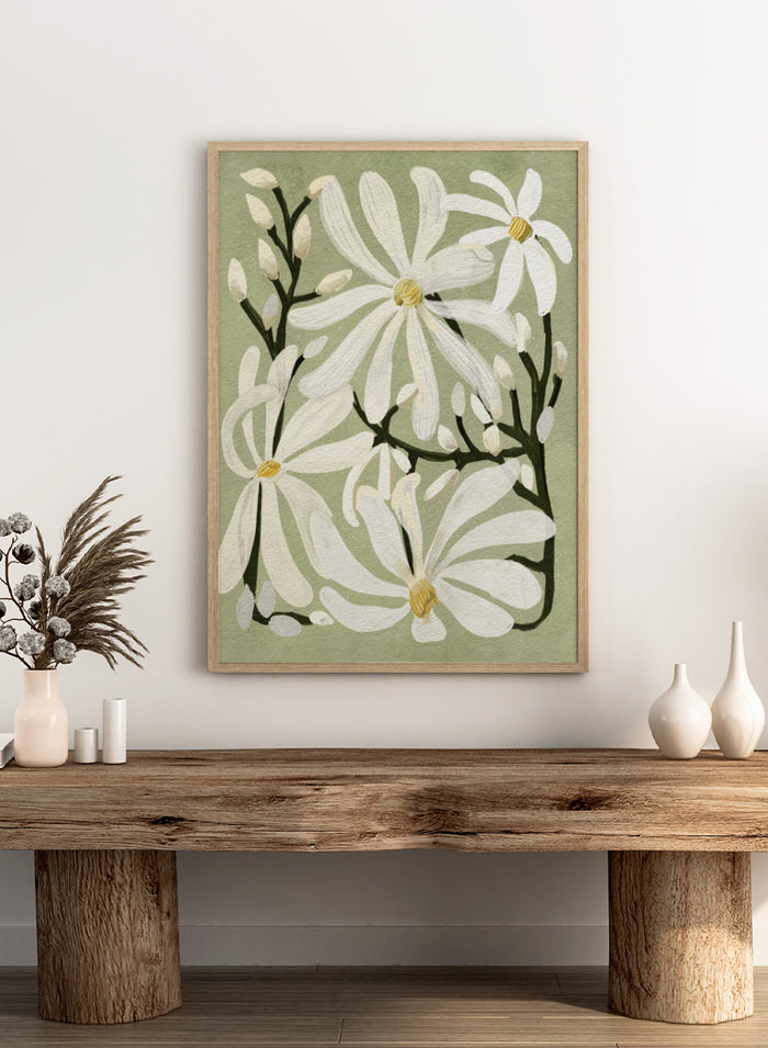 A botanical art print featuring white magnolia flowers with yellow centers and dark green stems on a muted sage green background. Shop Star Magnolia Floral Art Print by Katie O'Shea, a botanical floral art print featuring white magnolia blooms, dark branches, and a soft sage green background.