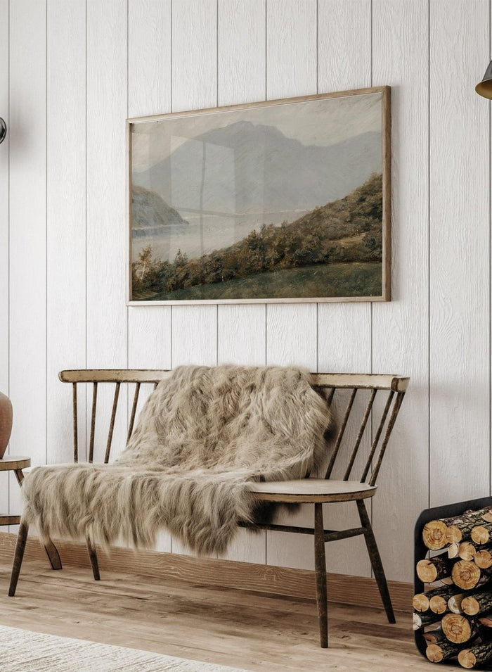 A framed landscape painting depicting a misty mountain range over a body of water with trees in the foreground. Landscape with Mountains in the Background by Susette Holten is a vintage mountain landscape print featuring a lake, misty peaks, trees, and muted natural tones.