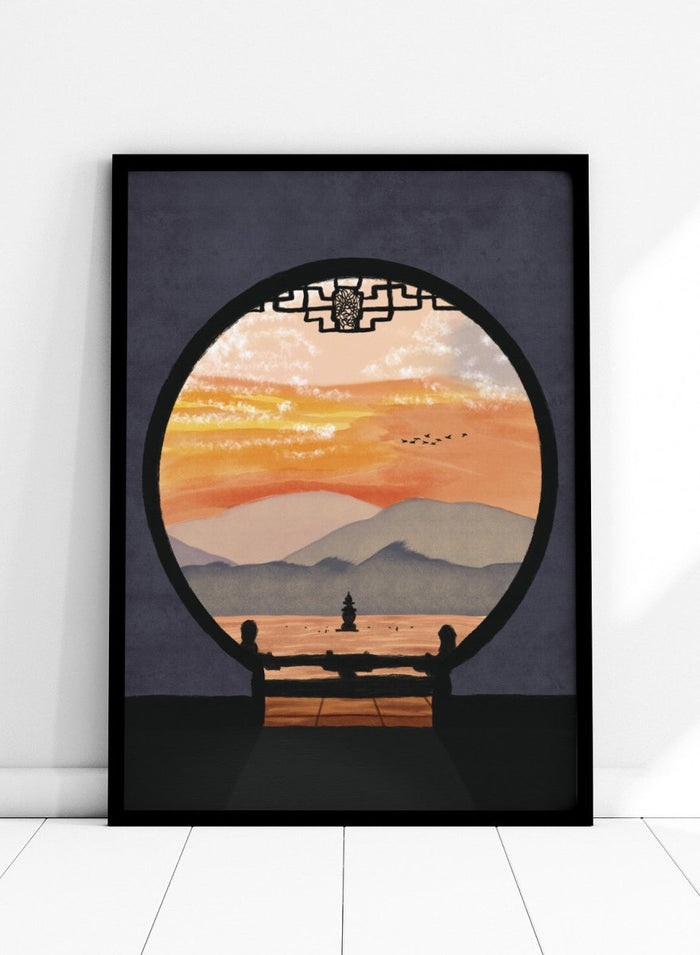 A framed art print depicting a scenic landscape viewed through a circular window frame. The scene shows layered mountains under a warm orange and yellow sunset sky with a small pagoda-like structure and birds, set against a dark gray background. Asian Pagoda Sunset View by Lisa Solomoniuk premium framed fine art print featuring layered mountains, a distant pagoda, and a glowing peach sunset.