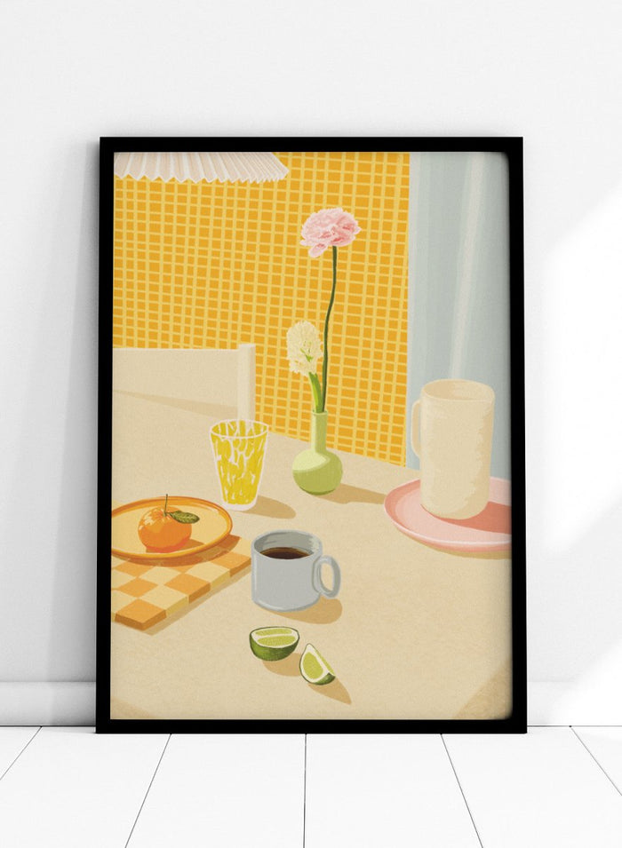 A stylized illustration of a tabletop scene with a pink flower in a small green vase, a yellow patterned glass, a white mug on a pink saucer, a gray mug of coffee, a sliced lime, and an orange on a checkered mat against a yellow tiled wall. Bright Breakfast Table by Lisa Solomoniuk premium framed fine art print featuring morning coffee, citrus fruit, flowers, and colorful tableware.
