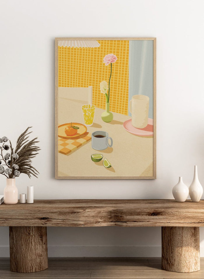 A stylized illustration of a tabletop scene with a pink flower in a small green vase, a yellow patterned glass, a white mug on a pink saucer, a gray mug of coffee, a sliced lime, and an orange on a checkered mat against a yellow tiled wall. Bright Breakfast Table by Lisa Solomoniuk premium framed fine art print featuring morning coffee, citrus fruit, flowers, and colorful tableware.