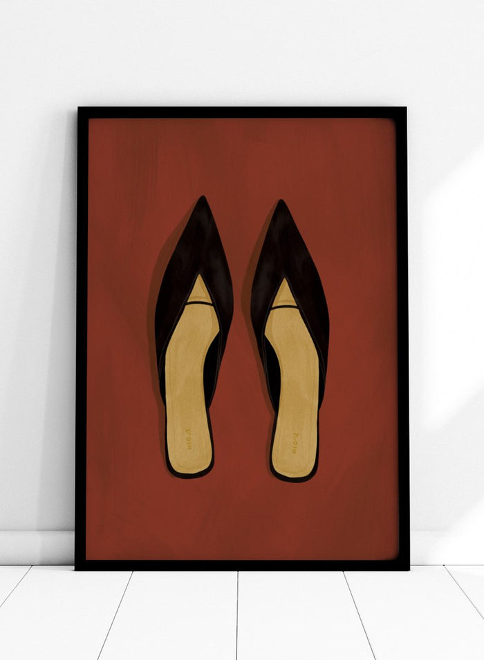A pair of black pointed-toe flat mules with a contrasting beige insole, displayed flat against a solid reddish-brown background. Chic Black Mules by Lisa Solomoniuk premium framed fine art print featuring pointed black shoes with golden insoles against a rich rust red background.