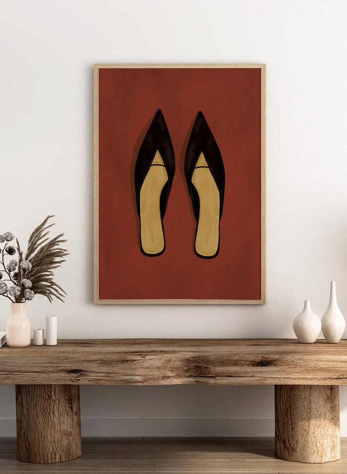 A pair of black pointed-toe flat mules with a contrasting beige insole, displayed flat against a solid reddish-brown background. Chic Black Mules by Lisa Solomoniuk premium framed fine art print featuring pointed black shoes with golden insoles against a rich rust red background.