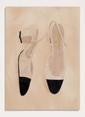 A pair of slingback flats with a beige and black color-blocked design, displayed on a textured beige background with a black border. Chic Cap-Toe Heels by Lisa Solomoniuk premium framed fine art print featuring cream slingback heels with black cap toes on a soft beige background.