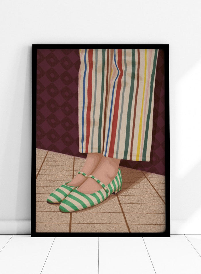 A close-up of a person's feet wearing green and white striped Mary Jane flats, paired with cream-colored striped trousers, standing on a tiled floor against a dark patterned wall. Colorful Striped Mary Janes by Lisa Solomoniuk premium framed fine art print featuring green striped shoes and colorful wide-leg trousers.