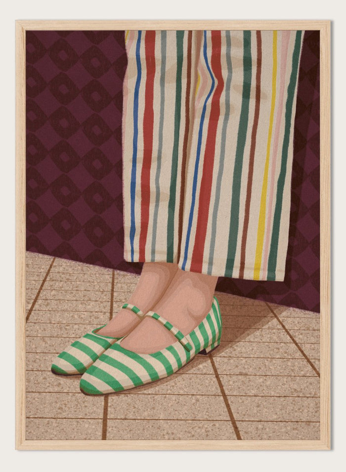 A close-up of a person's feet wearing green and white striped Mary Jane flats, paired with cream-colored striped trousers, standing on a tiled floor against a dark patterned wall. Colorful Striped Mary Janes by Lisa Solomoniuk premium framed fine art print featuring green striped shoes and colorful wide-leg trousers.