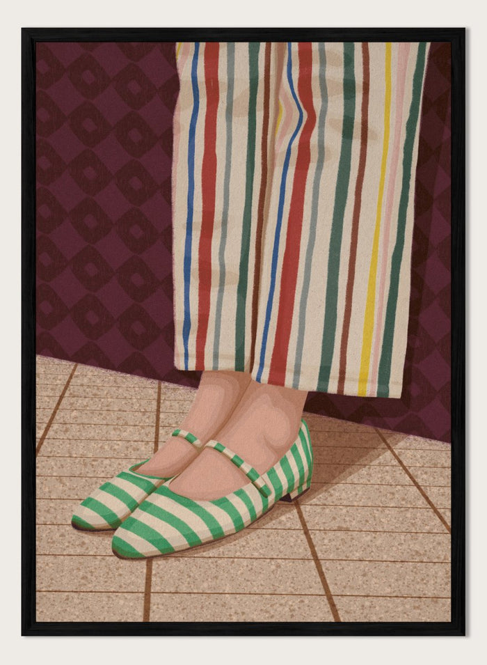 A close-up of a person's feet wearing green and white striped Mary Jane flats, paired with cream-colored striped trousers, standing on a tiled floor against a dark patterned wall. Colorful Striped Mary Janes by Lisa Solomoniuk premium framed fine art print featuring green striped shoes and colorful wide-leg trousers.