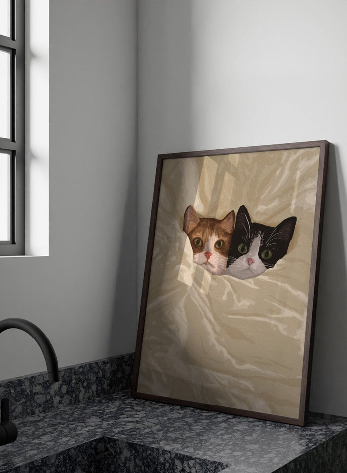 A stylized illustration of two cats peeking out from under a rumpled cream-colored blanket. The cat on the left is orange and white, and the cat on the right is black and white.  Cozy Cats Peeking Out by Lisa Solomoniuk premium framed fine art print featuring two cats tucked into soft cream bedding with wide-eyed expressions.