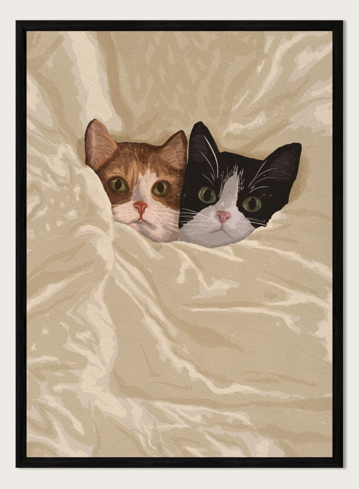 A stylized illustration of two cats peeking out from under a rumpled cream-colored blanket. The cat on the left is orange and white, and the cat on the right is black and white.  Cozy Cats Peeking Out by Lisa Solomoniuk premium framed fine art print featuring two cats tucked into soft cream bedding with wide-eyed expressions.