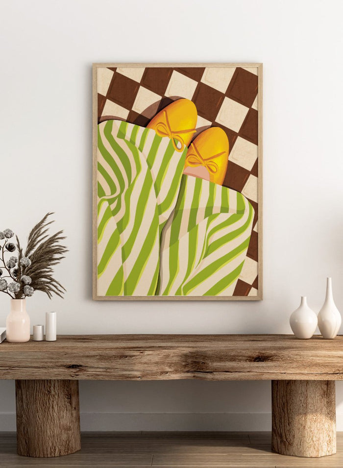 A stylized illustration of a person wearing green and white striped pajama pants and yellow slip-on shoes with bow details, lying on a brown and cream checkered floor. Cozy Striped Feet by Lisa Solomoniuk premium framed fine art print featuring yellow slippers, green striped trousers, and a bold checkered floor.