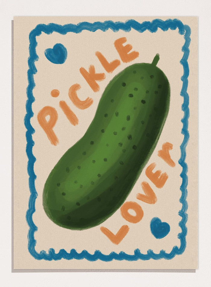 An art print featuring a hand-drawn green pickle centered on a cream background, surrounded by a blue scalloped border. The words 'PICKLE' and 'LOVER' appear in orange lettering, with two small blue hearts near the corners. Cute Pickle Lover by Lisa Solomoniuk premium framed fine art print featuring a giant green pickle, playful lettering, blue hearts, and a hand-painted border.