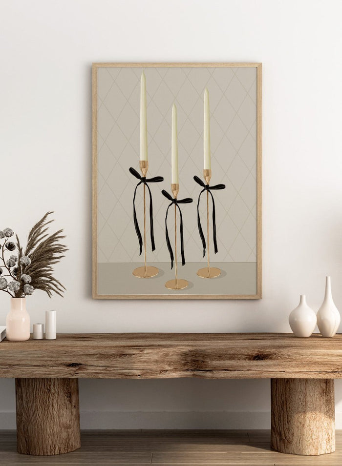 Three gold taper candle holders with cream candles and black ribbon bows, arranged on a light gray surface against a beige diamond-patterned background. Elegant Gold Taper Candles by Lisa Solomoniuk premium framed fine art print featuring gold candlesticks, cream tapers, and long black ribbons.