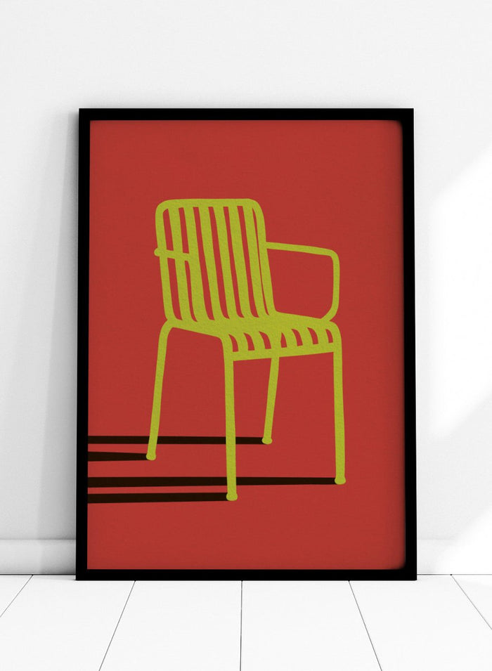 A minimalist graphic art print of a modern armchair, featuring a lime green chair silhouette on a solid red background with bold black shadows. Green Chair Shadow by Lisa Solomoniuk premium framed fine art print featuring a bright green chair and long black shadow against a deep red background.