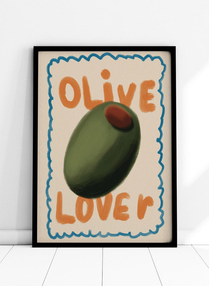 An art print featuring a stylized illustration of an olive with the words 'OLIVE' at the top and 'LOVE' at the bottom, framed by a blue scalloped border on a cream background. Green Olive Lover by Lisa Solomoniuk premium framed fine art print featuring an oversized green olive, orange lettering, and a playful blue border.