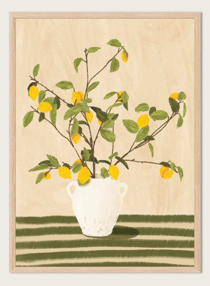 A framed still life artwork showing yellow lemons on leafy branches arranged in a white vase, set against a warm beige background with green horizontal stripes at the bottom. Lemon Tree Still Life by Lisa Solomoniuk premium framed fine art print featuring bright yellow lemons in a white vase on a striped green table.