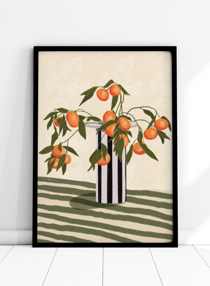 A stylized still life illustration of orange branches with green leaves and ripe oranges arranged in a black-and-white striped vase on a striped surface against a warm cream background. Orange Branches Vase by Lisa Solomoniuk premium framed fine art print featuring bright orange fruit, green leaves, and a striped black-and-white vase.