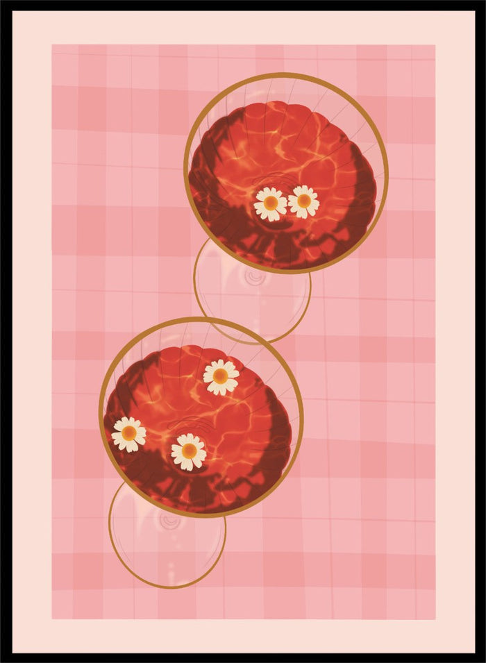 A stylized art print featuring two overlapping pink and red plaid glasses with white daisy flowers, framed by a black border on a light pink background. Pink Drinks With Daisies by Lisa Solomoniuk premium framed fine art print featuring red coupe glasses, floating daisies, and pink gingham.