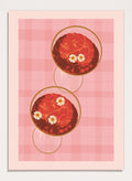 A stylized art print featuring two overlapping pink and red plaid glasses with white daisy flowers, framed by a black border on a light pink background. Pink Drinks With Daisies by Lisa Solomoniuk premium framed fine art print featuring red coupe glasses, floating daisies, and pink gingham.