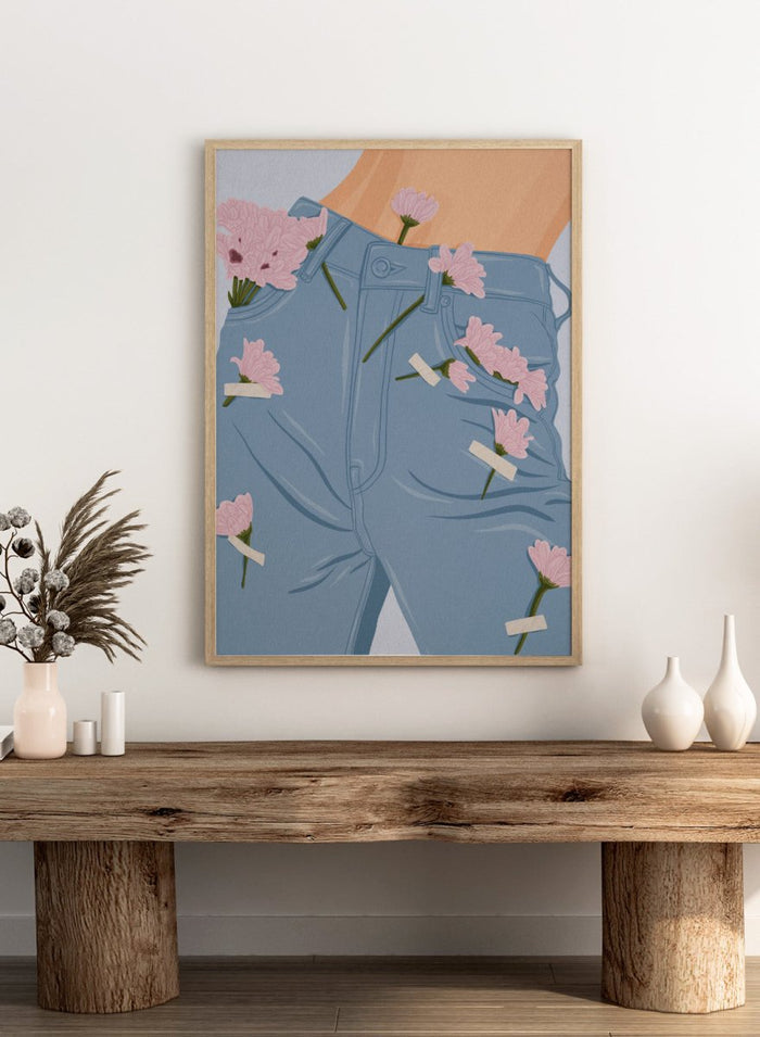 A stylized illustration of a person's lower torso wearing light blue jeans with several pink flowers pinned or attached to the fabric. The background is a pale blue-gray. Pink Flowers on Jeans by Lisa Solomoniuk fine art print featuring soft pink blooms tucked into light blue denim for a playful fashion-inspired look.