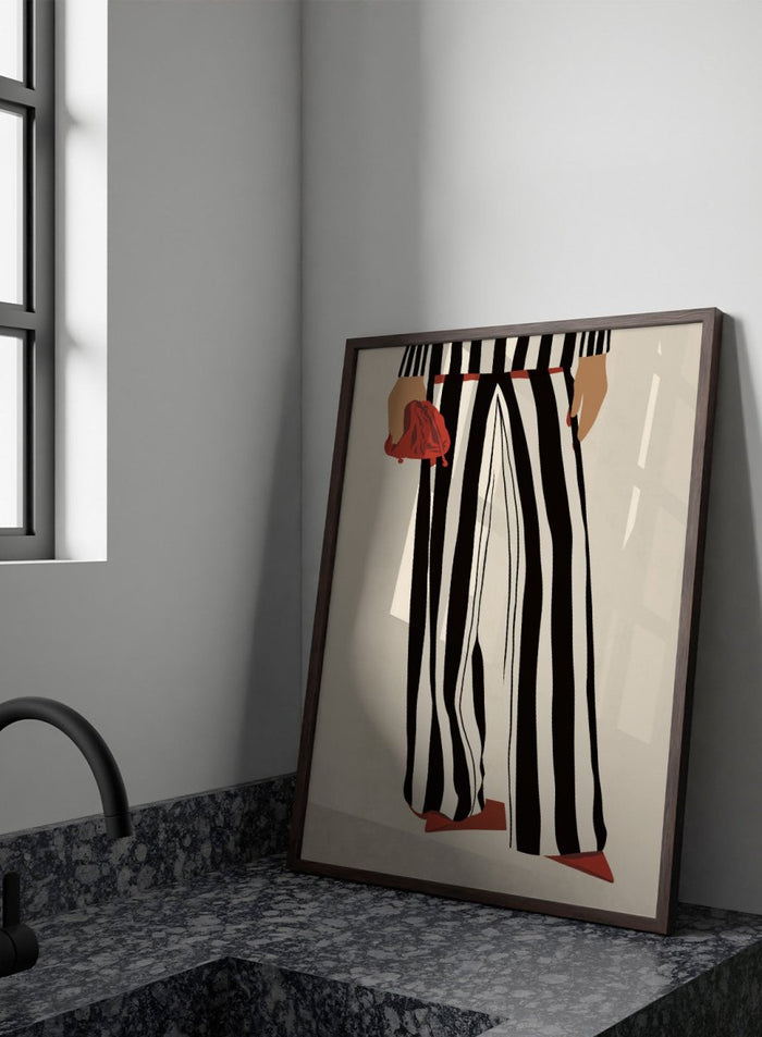 Fashion illustration of a person from the waist down wearing black and white vertically striped wide-leg trousers, with a red belt, red pointed shoes, and holding a red clutch against a cream background. Red Heels and Stripes by Lisa Solomoniuk premium framed fine art print featuring bold black-and-white stripes, pointed red heels, and a matching bag.