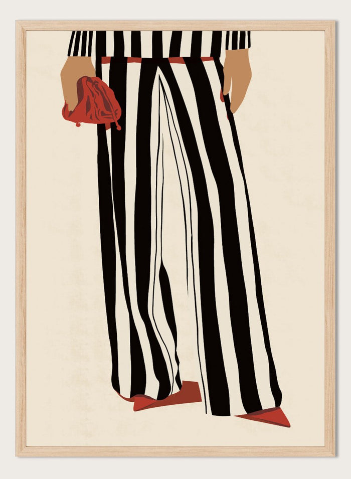 Fashion illustration of a person from the waist down wearing black and white vertically striped wide-leg trousers, with a red belt, red pointed shoes, and holding a red clutch against a cream background. Red Heels and Stripes by Lisa Solomoniuk premium framed fine art print featuring bold black-and-white stripes, pointed red heels, and a matching bag.