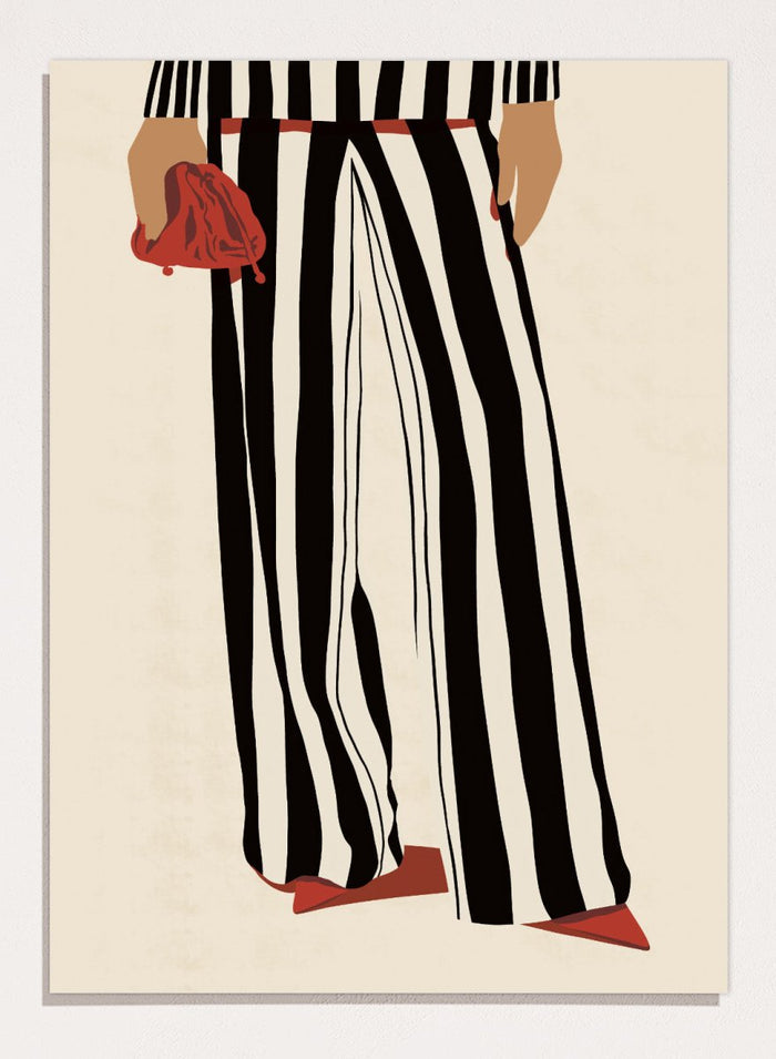 Fashion illustration of a person from the waist down wearing black and white vertically striped wide-leg trousers, with a red belt, red pointed shoes, and holding a red clutch against a cream background. Red Heels and Stripes by Lisa Solomoniuk premium framed fine art print featuring bold black-and-white stripes, pointed red heels, and a matching bag.