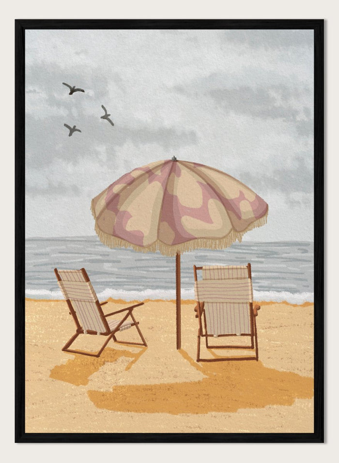 A beach scene artwork showing two wooden deck chairs under a beige and dusty pink patterned umbrella on a sandy shore, with the ocean and cloudy sky behind them. Two birds are visible in the sky. Seaside Umbrella Chairs by Lisa Solomoniuk premium framed fine art print featuring striped beach chairs beneath a fringed umbrella by the sea.