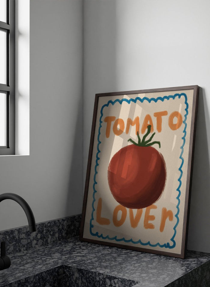 An art print featuring a painted red tomato with a green stem, surrounded by a scalloped blue border on a cream background. The words 'TOMATO' at the top and 'LOVER' at the bottom are written in orange hand-drawn lettering. Tomato Lover by Lisa Solomoniuk premium framed fine art print featuring an oversized tomato, playful hand-painted lettering, and a wavy border.