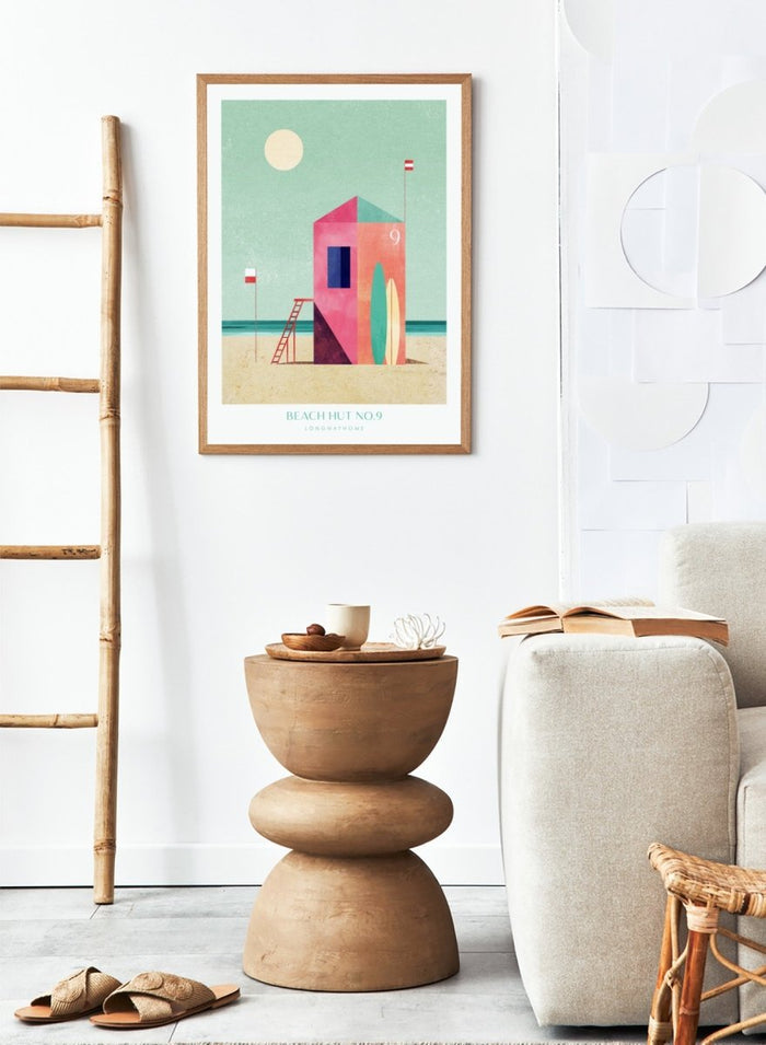 Colorful beach hut illustration with a minimalistic design on a light green background. Beach Hut Number Nine by Longwayhome is a retro inspired coastal art print featuring a colorful beach hut, surfboards, and minimalist seaside design.